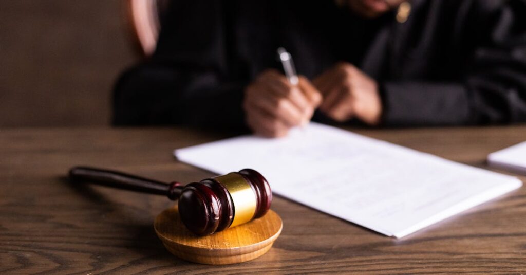 pexels-photo-6077447-6077447-2 Judge signing documents at desk with focus on gavel, representing law and justice.